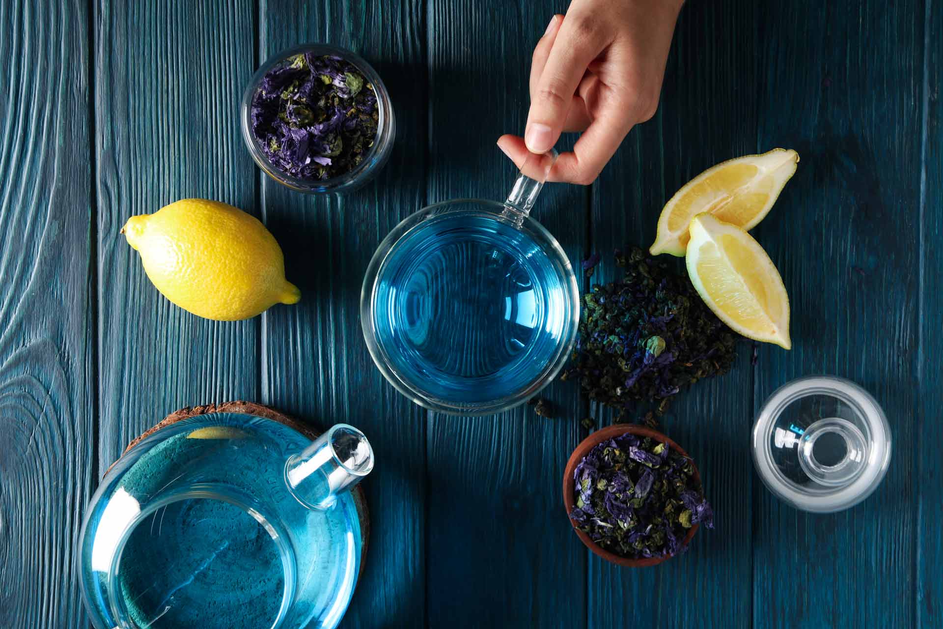 Teetasse und Teekräuter in blauer Glastasse